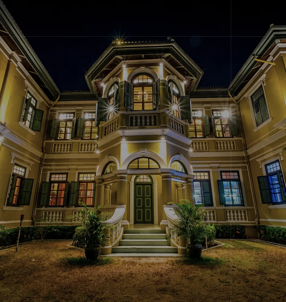 Fachada de mansão clássica iluminada à noite